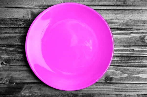 Pink plate on wooden table — Stockfoto