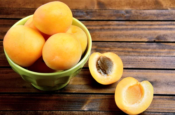 Green bowl with apricots — Stock Photo, Image