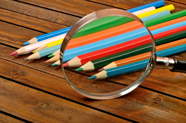 Magnifying glass with colorful pencil — Stock Photo, Image