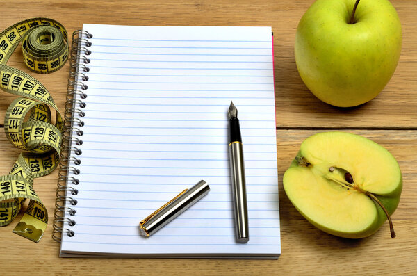 Notebook with green apple fruit and centimeter