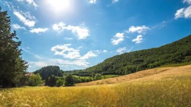 Timelapse kırsal manzara. Gün batımı ve hareketli bulutlar tepeler ve buğday alan üzerinde. Tuscany