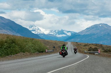 El Calafate 'deki dağlara doğru giden yolda iki motosiklet var.