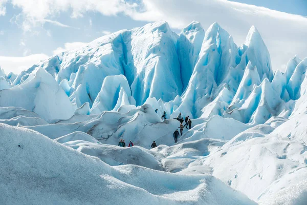 A Perito Moreno gleccser jégképződésének rétegei között sétáló turisták — Stock Fotó