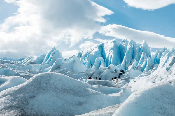 A Perito Moreno gleccser jégképződésének rétegei között sétáló turisták — Stock Fotó