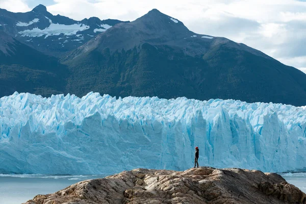 Egy nő a sziklán Perito Moreno gleccser mellett. — Stock Fotó