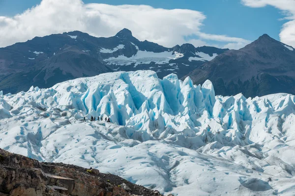 Turistas caminhando sobre a formação de gelo nevado da geleira Perito Moreno — Fotografia de Stock