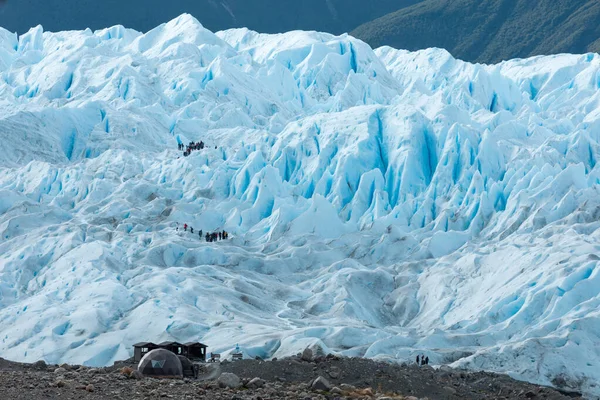 Туристи стоять на різних рівнях льодовика Періто - Морено. — стокове фото