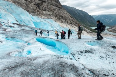 Jostedal Buzulu 'nun yüzeyinde yürürken ipi tutan turistler