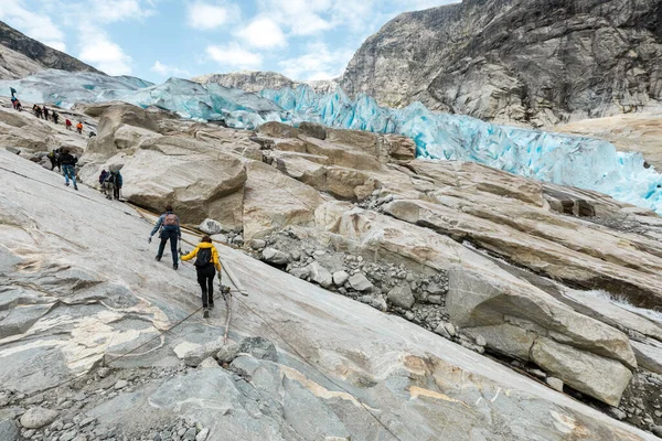 I turisti stanno scalando la superficie rocciosa del ghiacciaio di Jostedal — Foto Stock