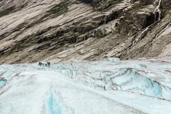 Les touristes sont debout sur la surface enneigée du glacier Jostedal — Photo