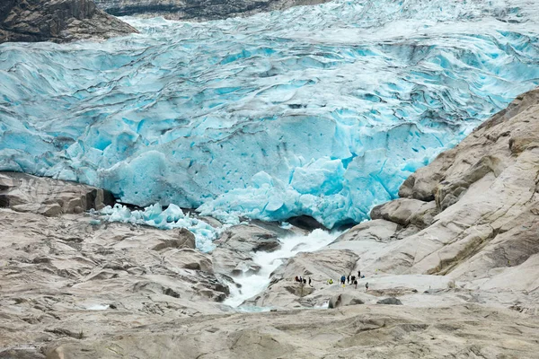 I turisti sono in piedi sulla superficie rocciosa del ghiacciaio di Jostedal — Foto Stock