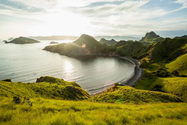 Padar adasının yeşil kaplı dağlarıyla çevrili körfez manzarası