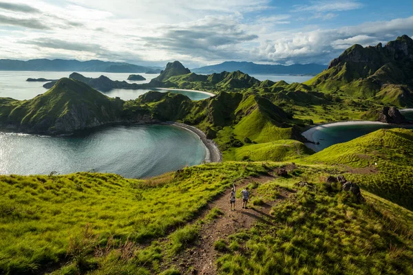 Padar adasının tepesinde yürüyen iki adam. 