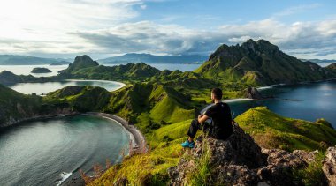 A man sitting on the rock on top of Padar island clipart