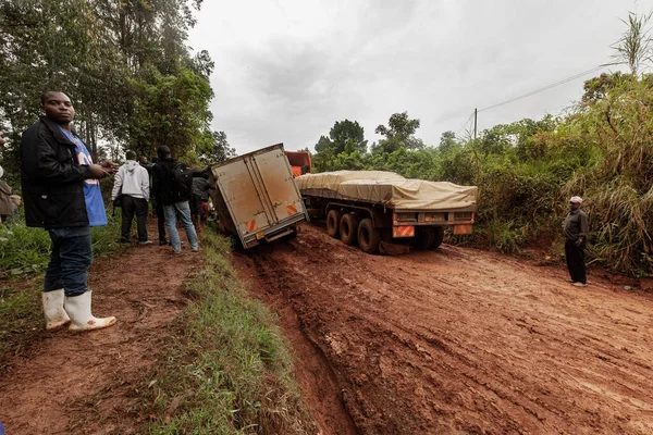 A truck stuck in the mud on a dirt road is helped out by local men. Uganda — Stock Photo, Image