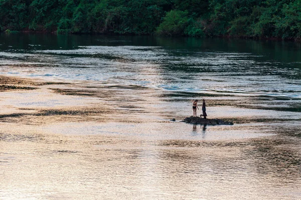 Δύο άνθρωποι στέκονται πάνω σε ένα βράχο σε ένα βάλτο νερό. Ziwa Rhino 'συλο, Ουγκάντα — Φωτογραφία Αρχείου