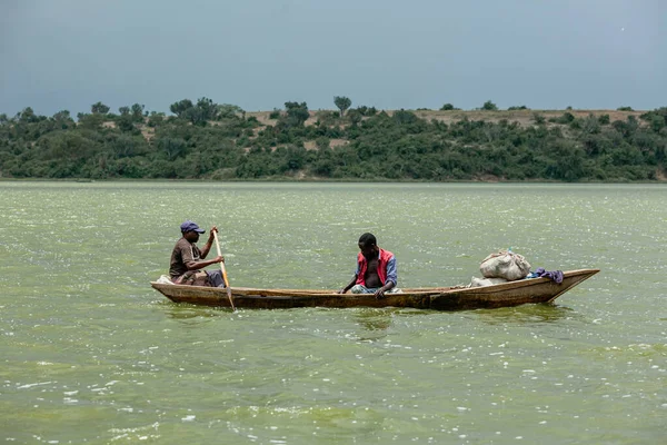 QUEEN ELIZABETH NATIONAL PARK, UGANDA - MARCH 14, 2018: Unidentified local men in the canoe in Kazinga Channel on March 14, 2018 in Queen Elizabeth National Park, Uganda — Stock Photo, Image