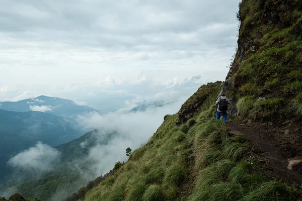 NEPAL - Május 31, 2016: Egy azonosítatlan ember sétál a keskeny nyomvonal szélén a hegy a túraútvonal Machapuchare május 31, 2016 Nepálban — Stock Fotó