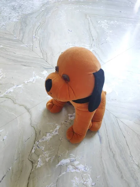 Cute Small Fluffy soft Toy dog on marble.