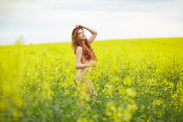 Chica desnuda de pie en el campo amarillo — Foto de Stock