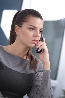 Ofisinde telefonu olan bir iş kadını.