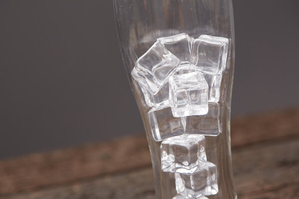 Glass with ice on wooden table