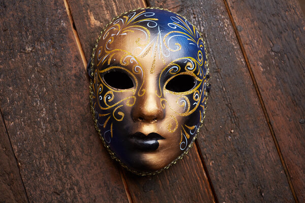 Венецианская маска на деревянном столе
