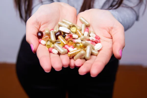 Pills and capsules in female hands — Stock Photo, Image
