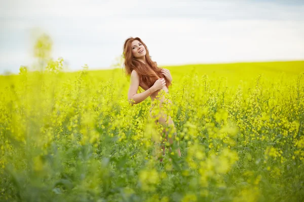 Chica desnuda de pie en el campo amarillo — Foto de Stock