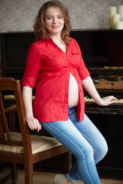 Zwangere vrouw in de buurt van piano — Stockfoto