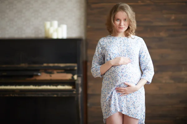 Mujer embarazada cerca de piano —  Fotos de Stock