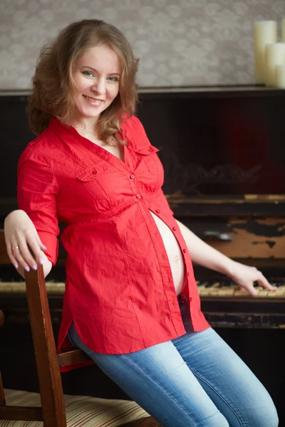 Donna incinta vicino al pianoforte — Foto Stock