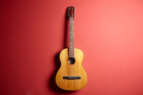 Guitarra clássica sobre um fundo vermelho — Fotografia de Stock