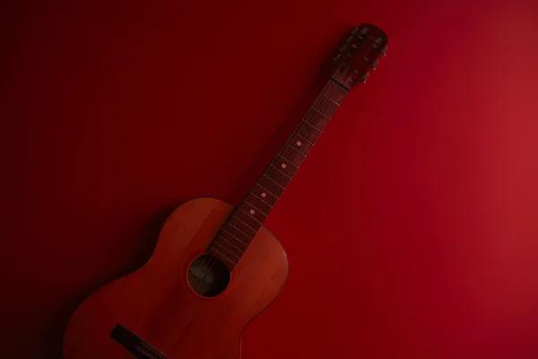 Guitarra clássica sobre um fundo vermelho — Fotografia de Stock