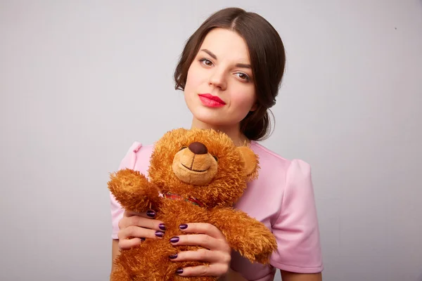 Mujer joven con un oso de peluche — Foto de Stock