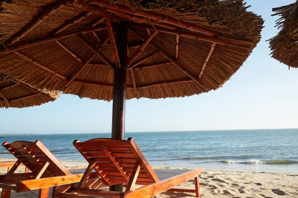 Sun lounger bawah payung di pantai — Stok Foto