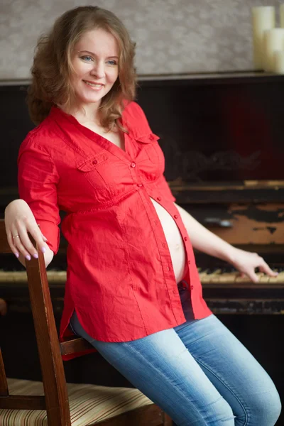 Έγκυος γυναίκα σε ένα κόκκινο πουκάμισο — Φωτογραφία Αρχείου