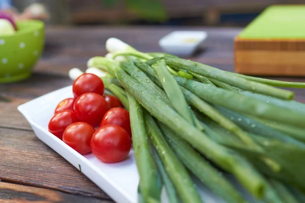 Körsbärstomater och salladslök — Stockfoto