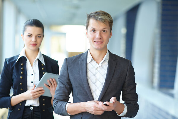 Businesswoman with tablet and businessman with telephone 