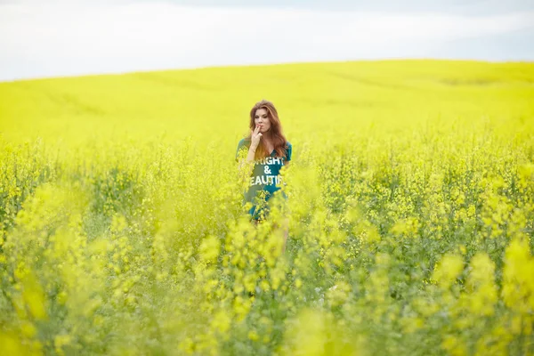 Chica pelirroja en campo de colza — Foto de Stock