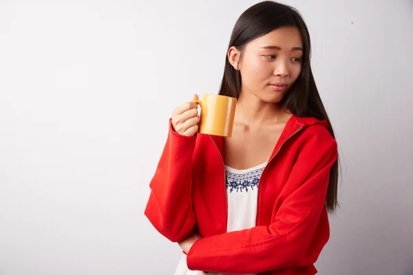 Chinese woman drinking from a mug — Stock Photo, Image
