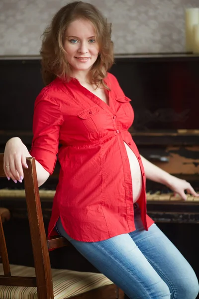 Mulher grávida em uma camisa vermelha — Fotografia de Stock