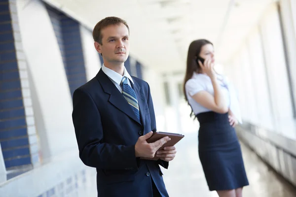 Empresária com telefone e empresário com tablet — Fotografia de Stock