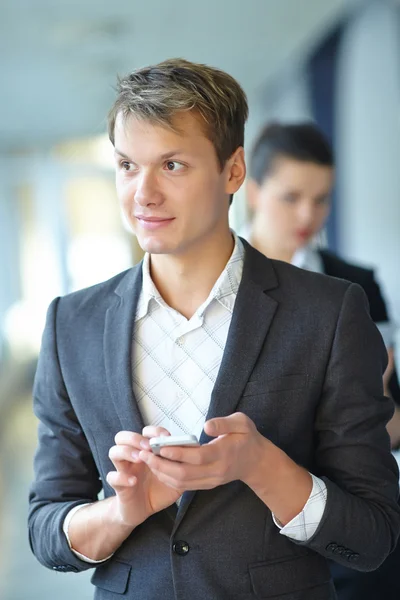 Joven empresario con teléfono y mujer de negocios — Foto de Stock