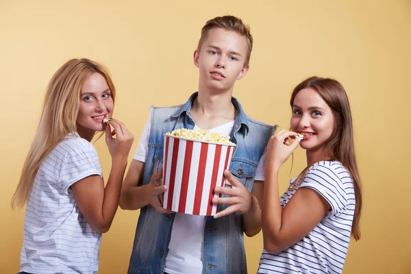 Kluk a dvě dívky s popcorn — Stock fotografie