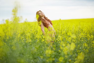 kolza tohumu alanındaki Kızıl saçlı çıplak kız