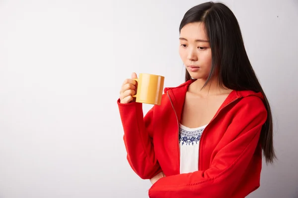 Chinese woman drinking from a mug — Stock Photo, Image