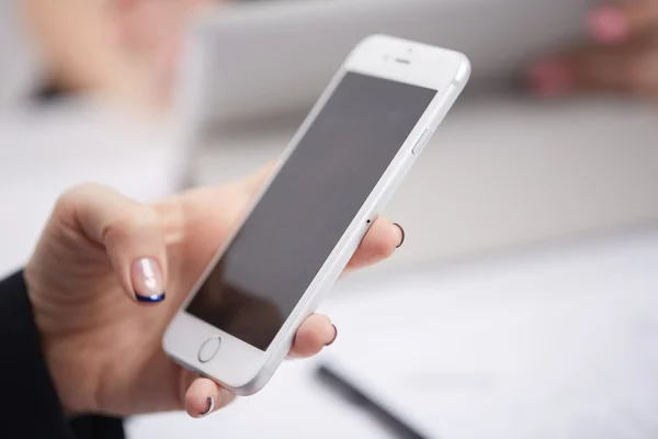 Mobiele telefoon in de handen van de vrouw — Stockfoto