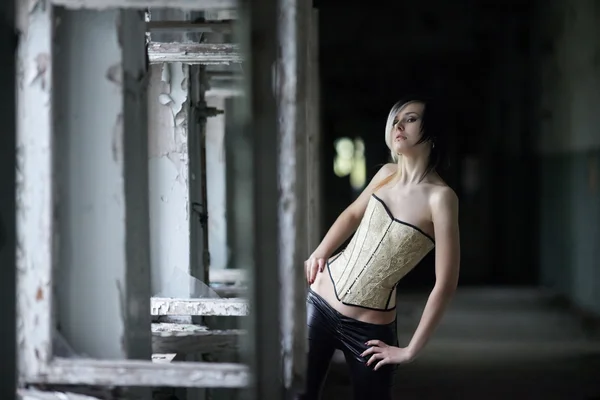 Girl with piercings in corset in corridor — Stock Photo, Image
