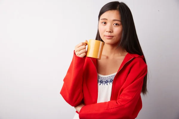 Chinese woman drinking from mug — Stock Photo, Image